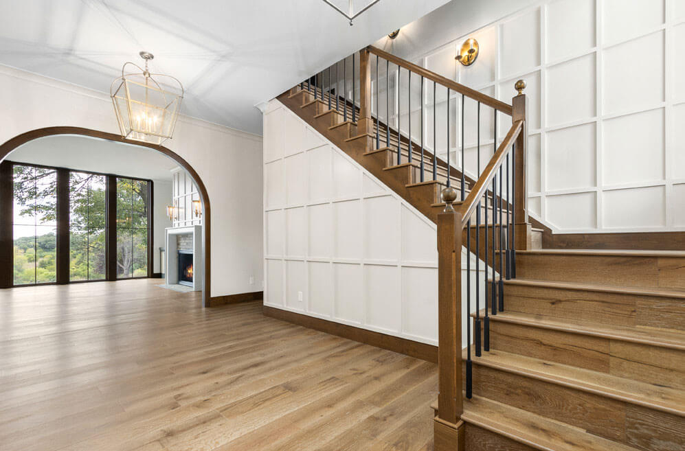 Staircase with wood treads and white paneled walls